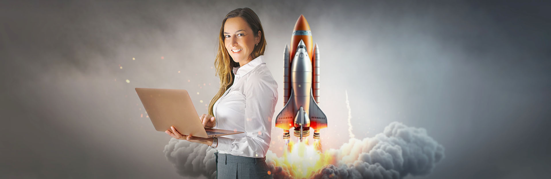 Woman holder laptop with rocket behind her