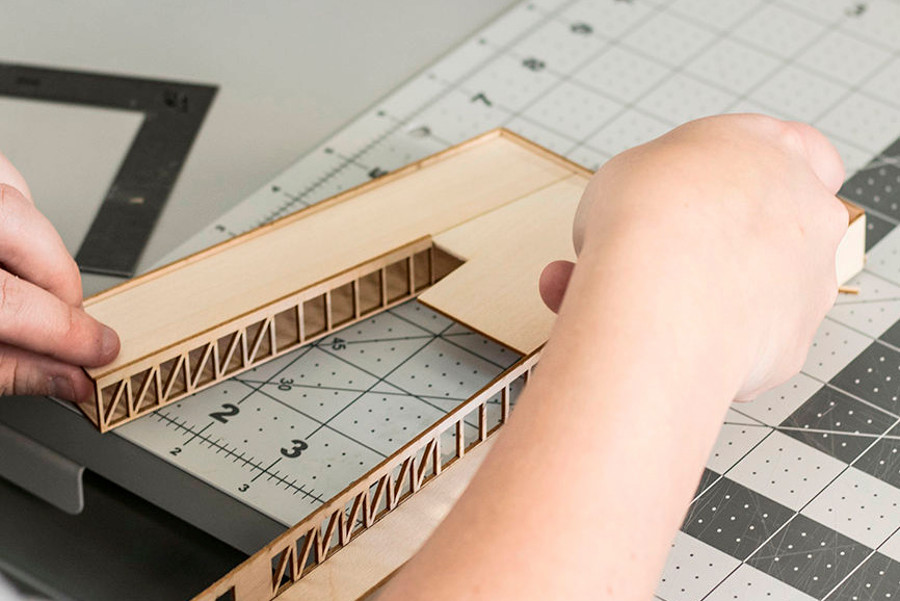 person working on wood building model