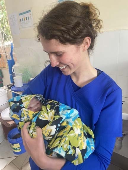 Rachel Girvin cradling a new born baby.