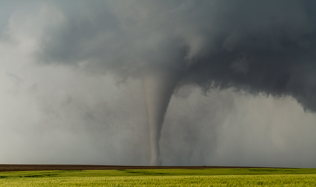 A tornado moves across an open field