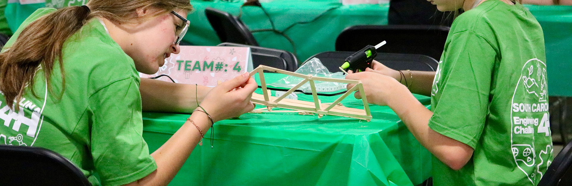 two kids working on their bridge made of chopsticks