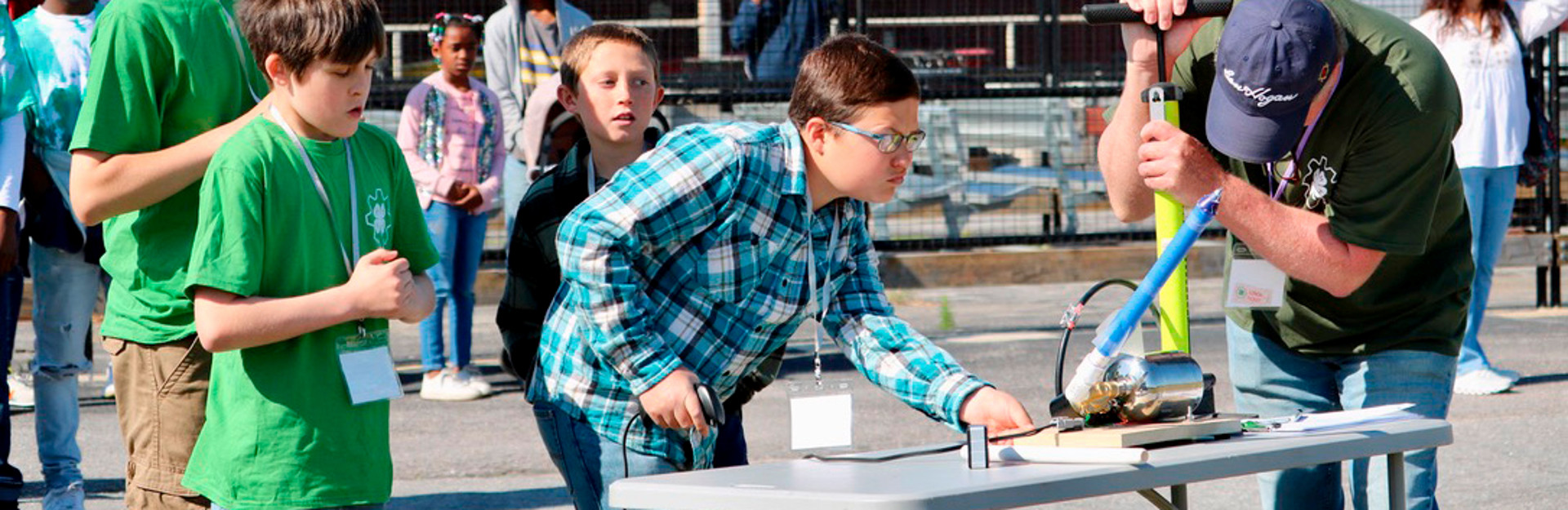 students preparing model rocket for launch