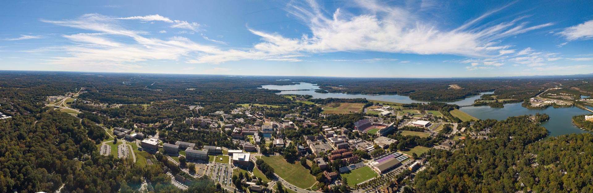 a panoramic shot of Clemson's campus and the lake and mountains beyond