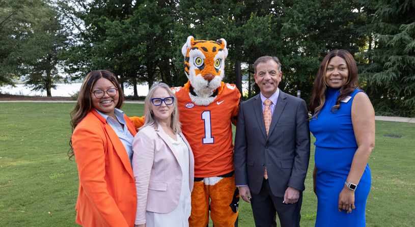 A group of GE leaders, Students, and Clemson Staff pose with the tiger mascot