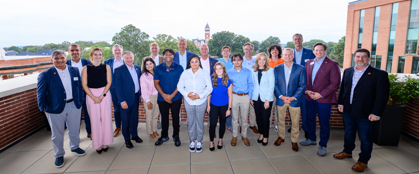 A group of students and staff pose with president Jim Clements