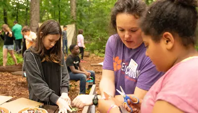 teacher and students in a forest