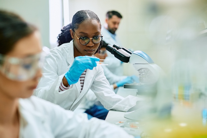 Clemson University School of Health Research scientist in front of a microscope