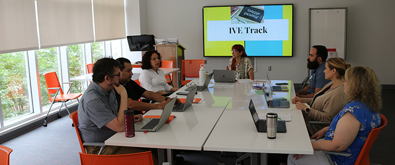 Faculty members working together at round table.