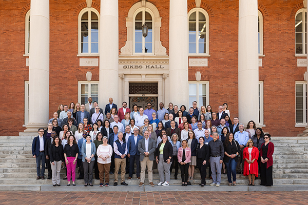 A large group photo of people who attended the ACC-ALN conference in front of Sikes Hall, featuring a diverse array of people.