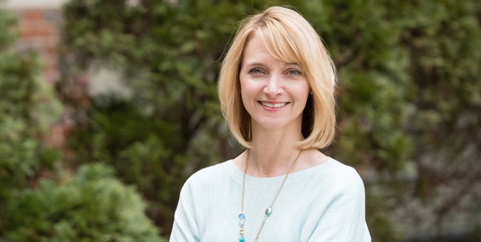 A Clemson faculty member standing in front of some greenery.