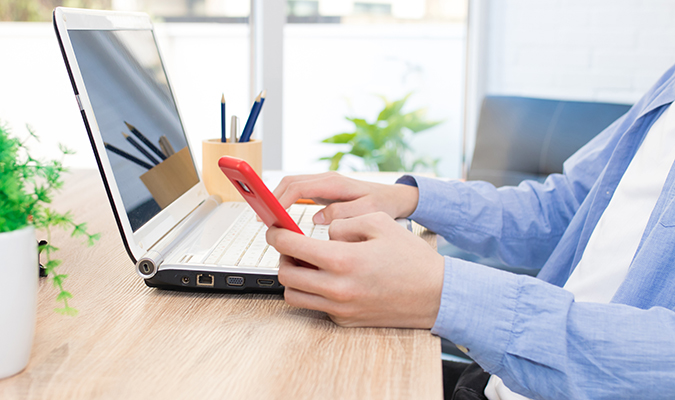 person using laptop and mobile device