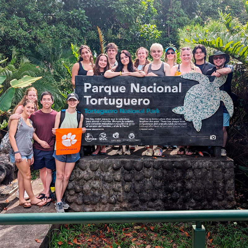 Group of students, holding orange Clemson flag, on street in Costa Rica.