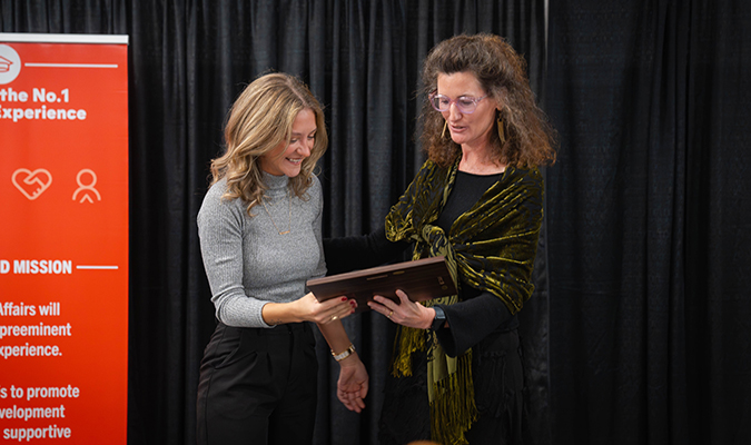 A Student Affairs staff member receives an individual excellence award from their presenter