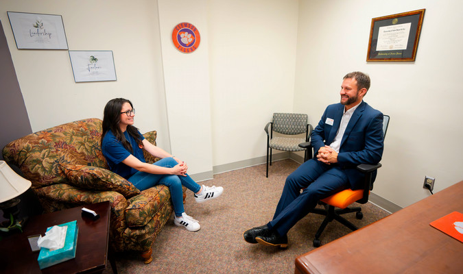 a smiling provider sits across a client in an office setting