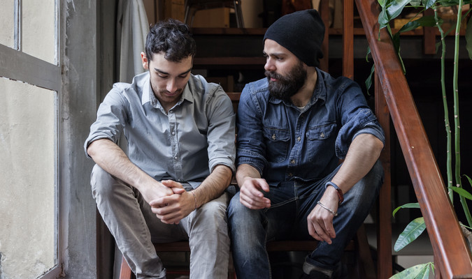 two young men talking on the stairs of an office