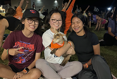 Clemson Students enjoying at U-NITES! event outside Barnes Center holding a deer fawn