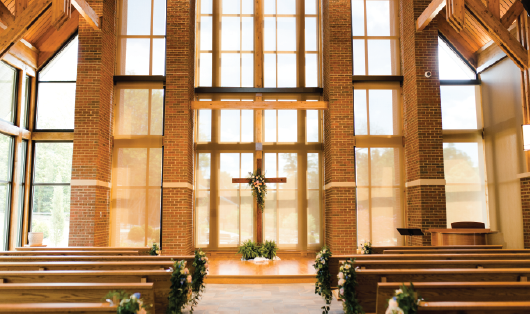 Floral cross placed on the platform inside the assembly room of the Samuel J. Cadden Chapel. 