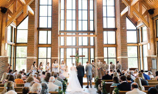 Attendees praying during wedding ceremony.