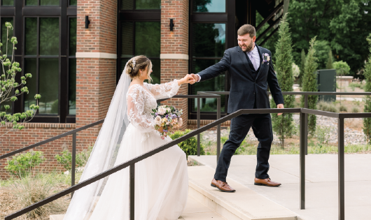 Husband and wife laughing in the garden after their wedding ceremony. 