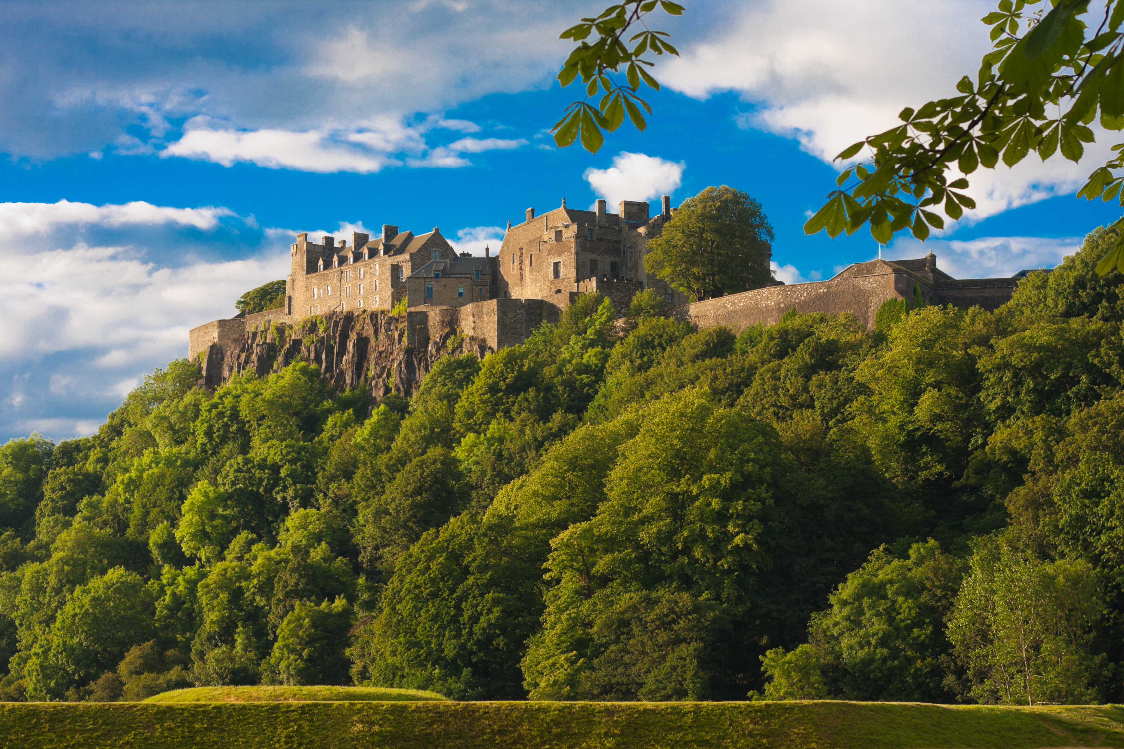 The Stirling Castle located on top of a green grassy hill