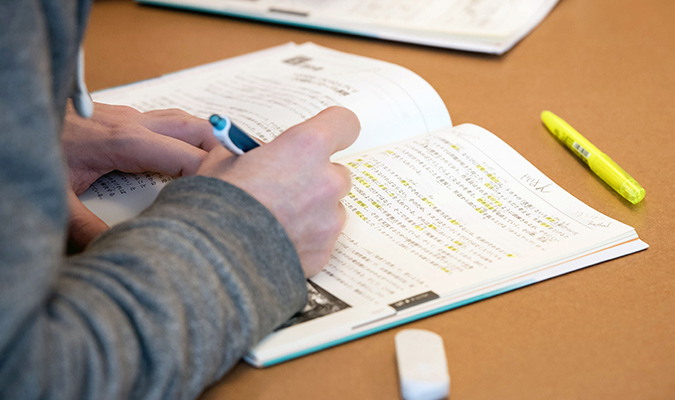 Person writing in a workbook.