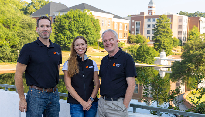 Clemson CVM faculty standing in front of the Reflection Pond with Old Main in the background.