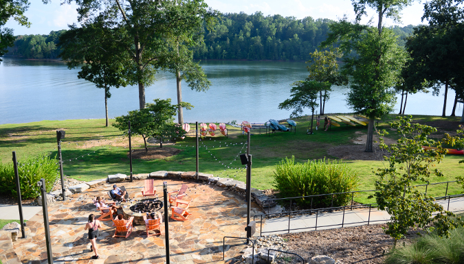 People gathered around a lake front fire pit at Clemson's Andy Quattlebaum Outdoor Education Center.